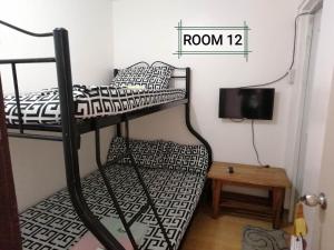 黎牙实比Thirdy's Place Hostel的客房设有两张双层床和电视。