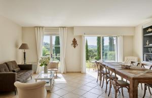 圣特罗佩Golf Resort & Country Club Saint-Tropez的客厅配有大型木桌和椅子