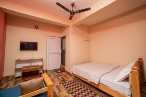 博卡拉Subedi Apartment的一间卧室配有一张床、一张桌子和吊扇