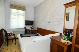 达洛科阿波罗酒店的一间卧室配有一张床、一张书桌和一个窗户。