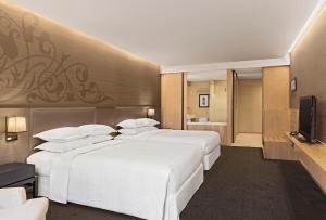 曼谷素坤逸 15 号喜来登曼谷四点酒店的酒店客房设有两张床和电视。