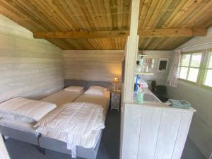 奥特罗Camping De Nieuwe Hof的一间卧室配有两张床和一个盥洗盆。