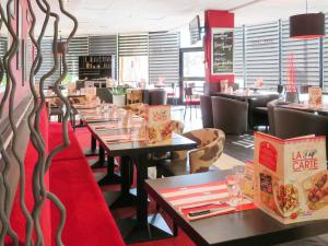 波尔多宜必思波尔多中心玛丽亚戴克酒店的一间设有桌椅和红地毯的餐厅