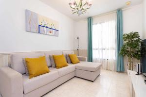 阿坎提拉德洛斯基拉斯弗洛雷斯别墅酒店的客厅配有白色沙发和黄色枕头。