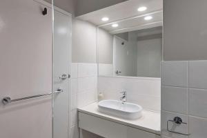 珀斯Pensione Hotel Perth的白色的浴室设有水槽和镜子