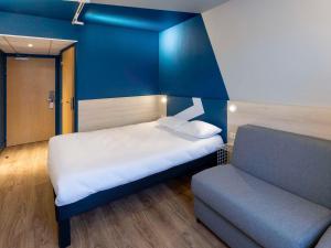 米洛ibis Budget Millau Viaduc的小房间设有床和沙发