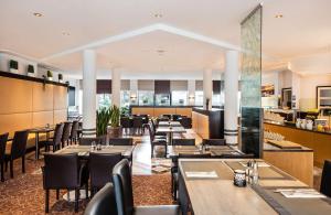 杜塞尔多夫Lindner Hotel Dusseldorf Airport, part of JdV by Hyatt的一间带桌椅的用餐室和一间餐厅