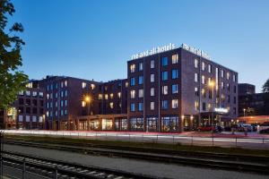基尔me and all hotel Kiel, part of JdV by Hyatt的毗邻火车轨道的建筑物