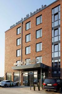 基尔me and all hotel Kiel, part of JdV by Hyatt的一座砖砌建筑,前面有汽车停放