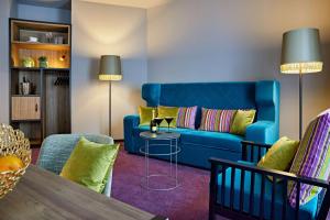 杜塞尔多夫me and all hotel Dusseldorf Oberkassel, part of JdV by Hyatt的客厅配有蓝色的沙发和桌子