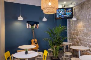 巴黎蒙马特丽晶嘻哈旅舍的一间配备有桌椅的用餐室和蓝色的墙壁