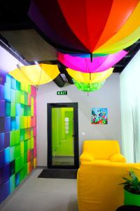 索非亚Green Cube Capsule Hostel的一间设有黄色沙发和多彩雨伞的房间