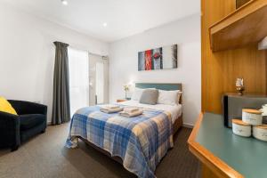 阿德莱德The Hidden Gem - Adelaide CBD的一间卧室配有一张带蓝色格子毯子的床
