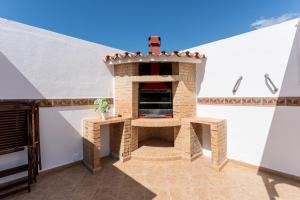 福恩吉罗拉MalagaSuite Skyviews Fuengirola的屋顶庭院里的砖炉