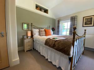 达特茅斯Downton Lodge Country Bed and Breakfast and; Self Catering的一间卧室配有带橙色枕头的床和窗户。