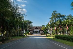 Si Maha PhotTawa Ravadee Resort Prachinburi, a member of WorldHotels Distinctive的一条有旗帜的房子前的空路