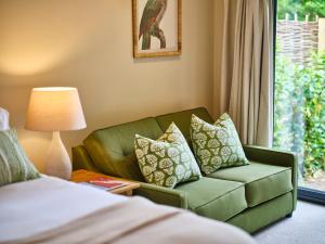贝里圣埃德蒙兹The Weeping Willow的客厅设有绿色沙发和窗户。