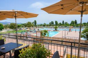 波普洛尼亚Poggio all'Agnello Sport & Active Holidays的享有带桌子和遮阳伞的游泳池的景色