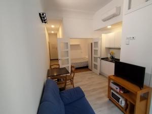 马德里Apartamento para 4 - Puerta del Sol的一间带蓝色沙发的客厅和一间厨房