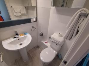 马德里Apartamento para 4 - Puerta del Sol的浴室配有白色卫生间和盥洗盆。