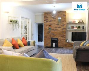 Spacious Modern House At Keysleeps Short Lets Northampton With Free Parking Garden的带沙发和壁炉的客厅