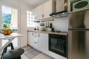 阿普索斯Terranova beach apartment - Menta的厨房配有白色橱柜和炉灶烤箱。
