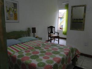 伊塔卡雷Casa de Vidro的卧室配有床、椅子和窗户。