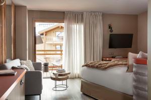 拉普德兹Grandes Rousses Hotel & Spa的酒店客房设有一张大床和一台电视。