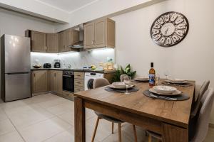 扎金索斯镇Aria Apartment的厨房配有木桌和墙上的时钟