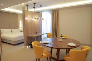 塔什干Apart Hotel Istaravshan的配有桌椅和床的房间