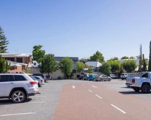 弗里曼特The Beaconsfield Hotel的停车场有许多车辆停放在里面