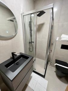 萨拉热窝Hotel Brkic的一间带玻璃淋浴和水槽的浴室