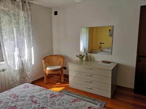 巴切诺Casa Il Glicine的一间卧室配有梳妆台、镜子和椅子