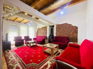 米特罗维察Villat Bardhoshi的客厅配有红色椅子和砖墙
