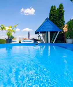 SármellékElena Apartaments的蓝色的游泳池,带有蓝色的屋顶