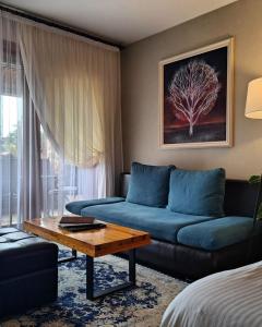 贝罗沃极光水疗度假酒店 的客厅配有蓝色的沙发和桌子
