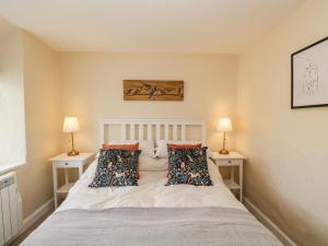 莱奇莱德Wharf Cottage的卧室配有带两盏灯的白色床