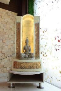 阿姆利则Sukhmanee Home Stay的坐在钟的佛陀雕像