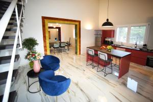 San Corrado di FuoriVilla Pica by PosarelliVillas的厨房以及带蓝色椅子和柜台的起居室。