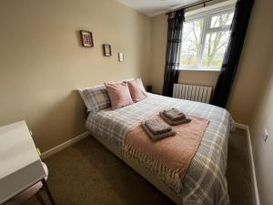 温彻斯特Charming 4-Bed House in Winchester Free Parking的一间卧室配有一张床,上面有两条毛巾