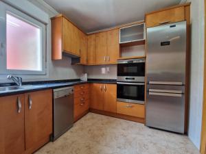 格乔Family Apartment / Apartamento familiar Getxo的厨房配有木制橱柜和不锈钢用具
