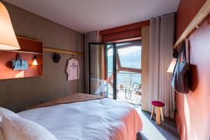 里昂里昂合流摩巴酒店的一间卧室设有一张床和一个阳台的窗户。
