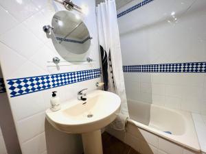 韦尔瓦Marina 4 apartment的浴室配有盥洗盆、镜子和浴缸