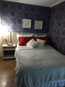 沙佩科Gastaldon Suite的一间卧室配有红色和白色枕头的床