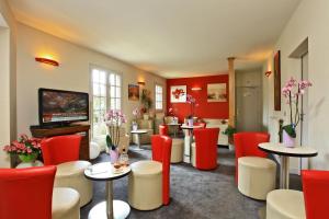 格拉马Hostellerie du Causse的一间设有红色和白色椅子和桌子的等候室