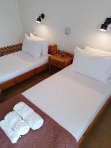 圣加利尼Loggia的配有2张床的带白色床单和枕头的客房