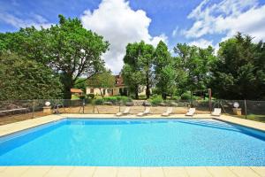 格拉马Hostellerie du Causse的一个带躺椅的游泳池以及一座房子