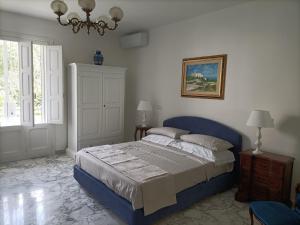 莱切Il Giardino della Scuncerta的一间卧室配有蓝色的床和吊灯。