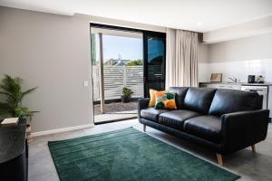 Kalbar107 George的客厅配有黑色真皮沙发和绿色地毯。