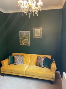 诺里奇The Lodge at Salhouse的客厅里一张黄色的沙发,配有吊灯